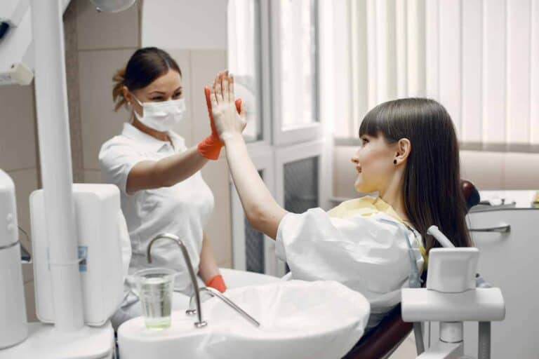 higienistka z pacjentka przybija piątke
